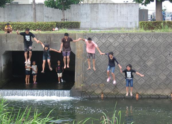  川に飛び込んで遊ぶ中高生たち